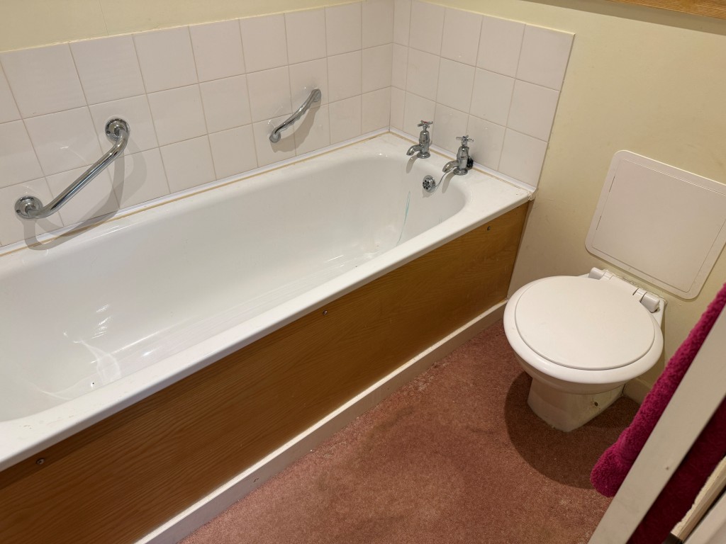Lot: 130 - TWO-BEDROOM GROUND FLOOR FLAT IN NEED OF UPDATING CLOSE TO SEAFRONT - White bathroom suite with WC